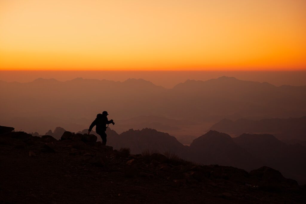 a person standing on top of a mountain at sunset