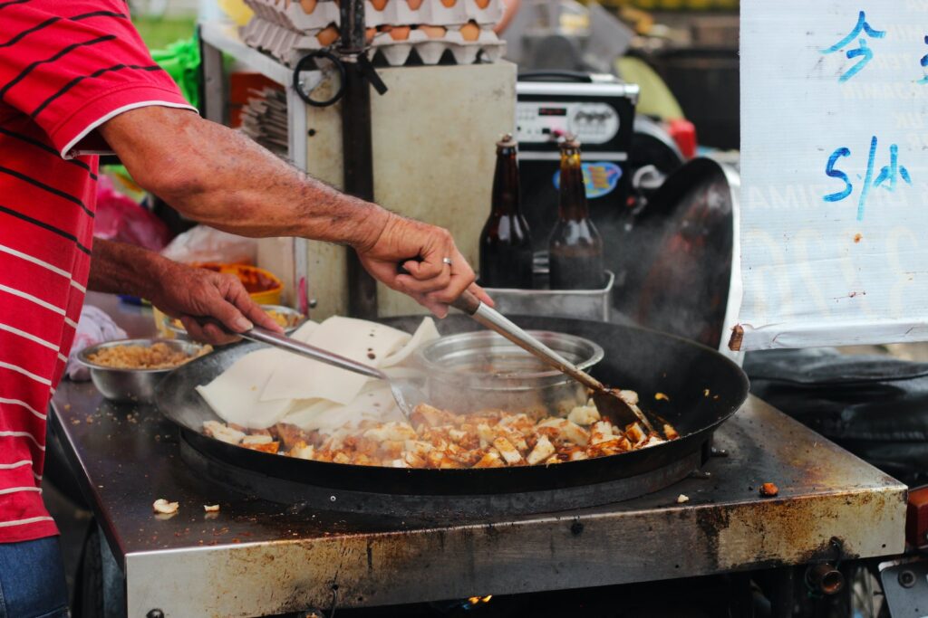 man in red t-shirt cooking food